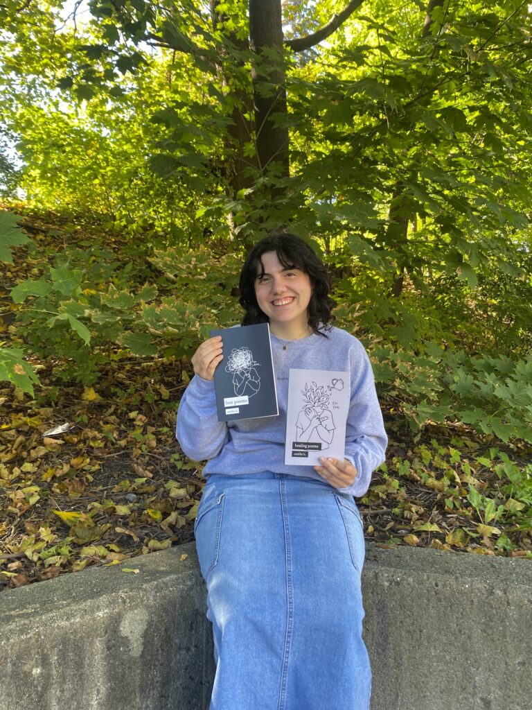 L'autrice d'Embrun, Amélie Bouthillier, tenant ses deux livres, poèmes perdus (à gauche) et poèmes de guérison (à droite).