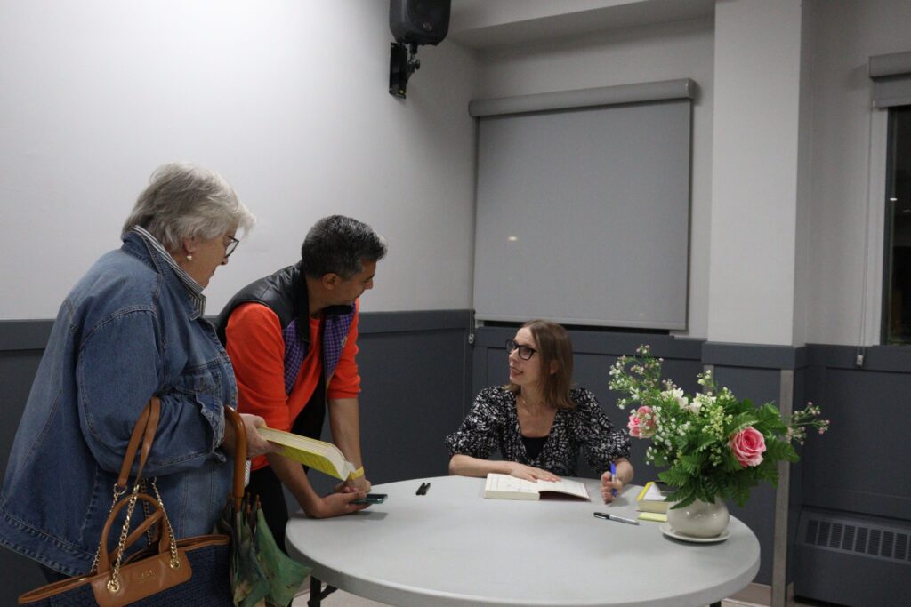 Nita Prose chats with fans as she signs their copies of her novels following her talk in Russell.