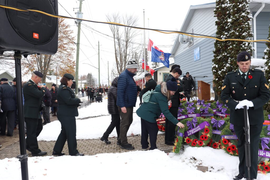 Des résidents déposent leurs coquelicots sur les couronnes en hommage aux anciens combattants, lors de la cérémonie du Jour du Souvenir organisée par la Légion de Russell.