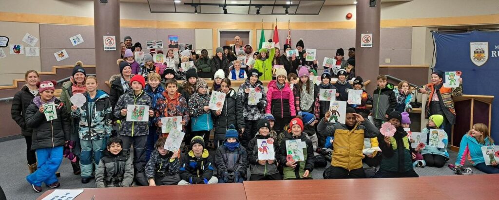 Plus de 55 élèves des écoles d’Embrun présentent fièrement leurs dessins en hommage aux vétérans, en compagnie du maire de la municipalité de Russell, Mike Tarnowski, lors des activités du Jour du Souvenir organisées par le Club Richelieu Embrun.