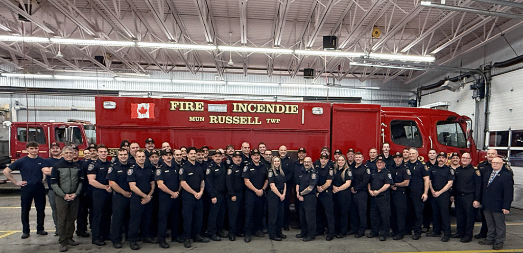 Des pompiers des casernes 11 et 12 de la Municipalité de Russell posent aux côtés du nouveau camion pompe/sauvetage lors de la traditionnelle cérémonie de poussée tenue le 6 janvier 2026.