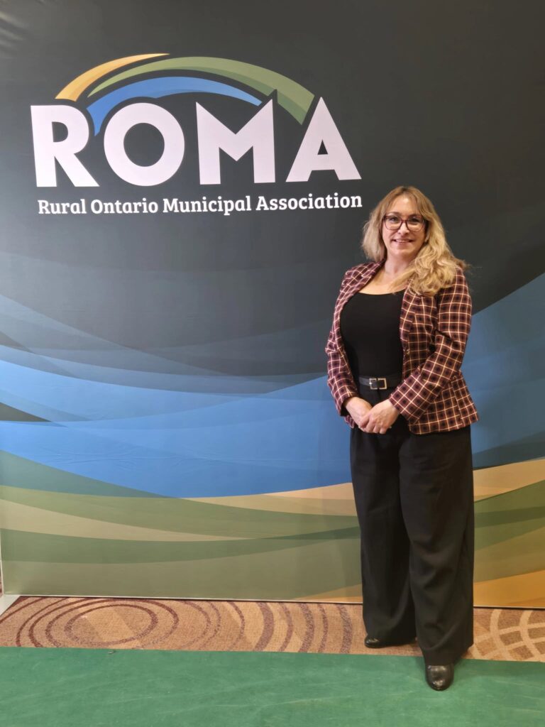 Casselman Mayor Geneviève Lajoie stands next to a ROMA sign in Toronto during the 2026 Rural Ontario Municipal Association Conference, where she advocated for municipal priorities including long-term water security, healthcare access, and community infrastructure.