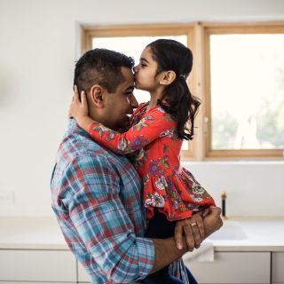 Daughter kissing father at home