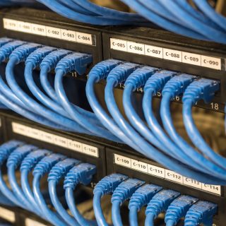 rows of network cable connected to router and switch hub in server room