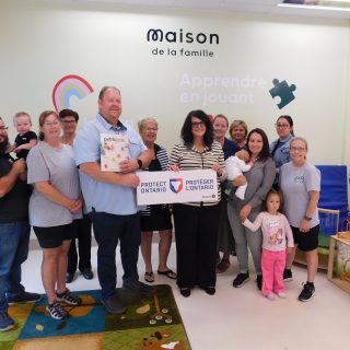 Stéphane Sarrazin, député provincial de Glengarry-Prescott-Russell, Judith Gour, directrice générale du Groupe Action (au centre), ainsi que le personnel et les sympathisants de la Maison de la Famille Hawkesbury Family Centre célèbrent l’approbation d’une subvention de 162 000 dollars du Fonds Trillium de l’Ontario pour ce service de garde d’enfants à but non lucratif.