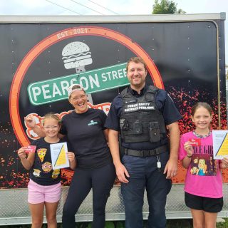 Saphyrëlle and Kaëlly Laroche proudly pose with Public Safety officer Jonathan Guidon after receiving a positive ticket for their civic-minded actions. The two young girls distinguished themselves by actively helping to keep Yahoo Park clean by picking up litter left behind, demonstrating their sense of responsibility and concern for the environment. To recognize their actions, they each received a Tim Hortons gift card, a small token of encouragement that reflects the importance of positive community initiatives.