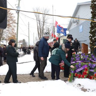 Des résidents déposent leurs coquelicots sur les couronnes en hommage aux anciens combattants, lors de la cérémonie du Jour du Souvenir organisée par la Légion de Russell.
