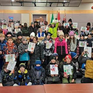 Plus de 55 élèves des écoles d’Embrun présentent fièrement leurs dessins en hommage aux vétérans, en compagnie du maire de la municipalité de Russell, Mike Tarnowski, lors des activités du Jour du Souvenir organisées par le Club Richelieu Embrun.