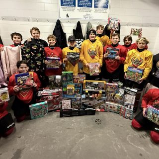 Des enfants sourient en tenant les cadeaux reçus grâce à la campagne des Lutins de Noël de Valoris, rendue possible par la générosité de la communauté.