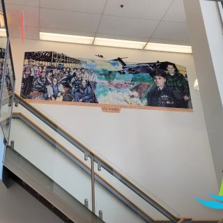 Une version restaurée de la murale de la Victoire de St-Isidore orne maintenant l'aréna, préservant l'histoire militaire de la communauté et les noms de ceux qui ont servi.