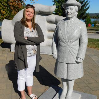 Tina Desbarais, coordonnatrice de l'événement Journée du drapeau de cette année à Hawkesbury (à gauche), pose avec la statue de Mme Armande Berthiaume au Monument de la Francophonie à l'Île du Chenail.