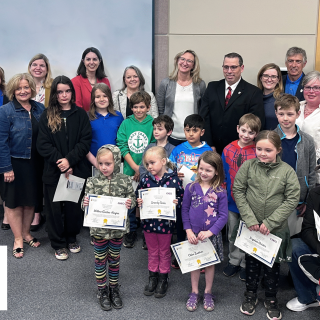 Shown in the photo in no particular order are Rory Renwick and the 11 children on the bus (Jake Vaughn, Nathan Vaughn, Levi Helmer, Amir Sakhizadeh, Chloe Butcher, Christopher Butcher, Nicholas Butcher, Daphne Geisler, Dylan Geisler, Serenity Geisler, and Willow Geisler-Harper), Tammy DeGiovanni (CHEO Senior VP, Clinical Services and Chief Nursing Executive), Jennifer Proulx (CHEO VP, Child Development and Community Services), Karen Macaulay (CHEO VP, Acute Care), Ron Ferguson (UCDSB Director), Susan Rutters (UCDSB Superintendent), Karina Parisien (UCDSP Trustee), Nichola Bond (Russell PS Principal), Erin O'Rourke (Russell PS Vice-Principal), Brian McBain and Ian Courville (Fire Chief & Deputy Fire Chief for Russell Township Fire Services), Millie Bourdeau (Director of Public Safety en Enforcement), Jamie Laurin (Interim Mayor), Lisa Deacon (Councillor), and Marc Lalonde (Councillor).