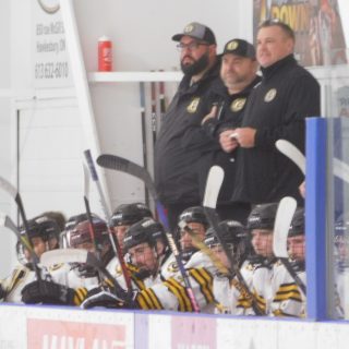 Vankleek Hill Cougars coaches and players look on from the bench.